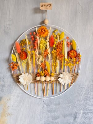 Pomarańczowo-żółta dekoracja na ścianę z suszonymi kwiatami