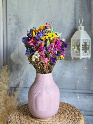 Kolorowy bukiet suszonych kwiatów i zbóż w różowym wazonie
