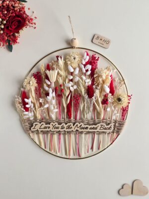 Dekoracja ścienna z suszonymi kwiatami i napisem I love you to the moon and back